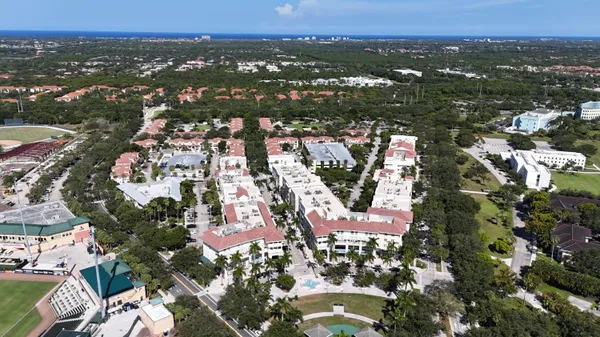 an aerial view of a residential houses with outdoor space and trees