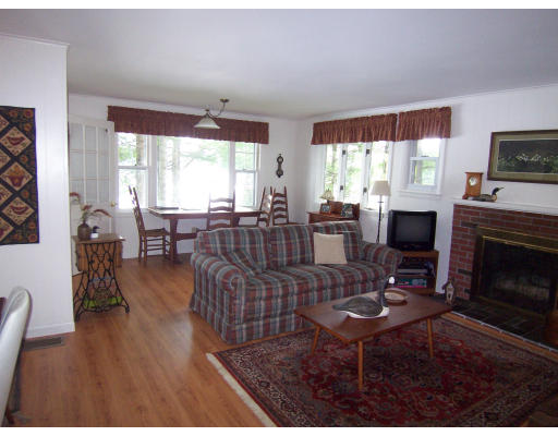 28 Beach Road Ware, MA 01082 - Photo 11 of 16 a living room with fireplace furniture and a large window