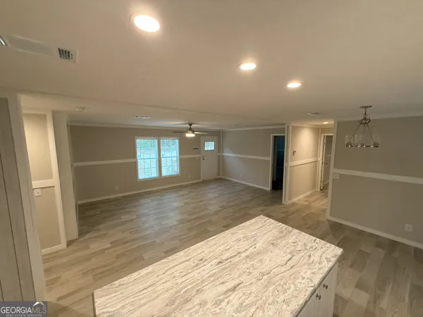 wooden floor in an empty room with a kitchen