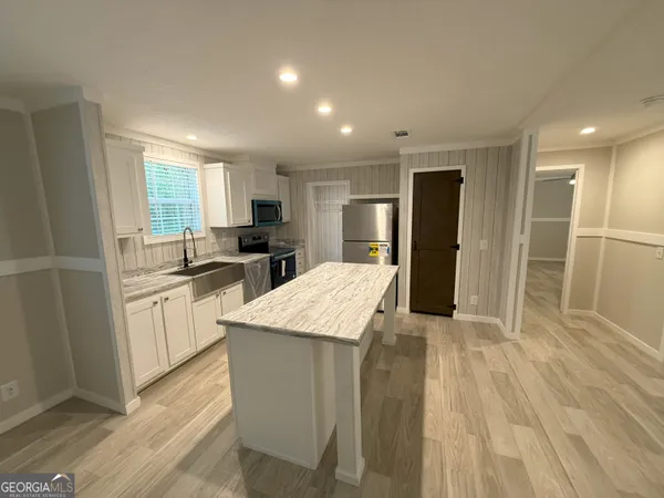 a large kitchen with a center island and stainless steel appliances