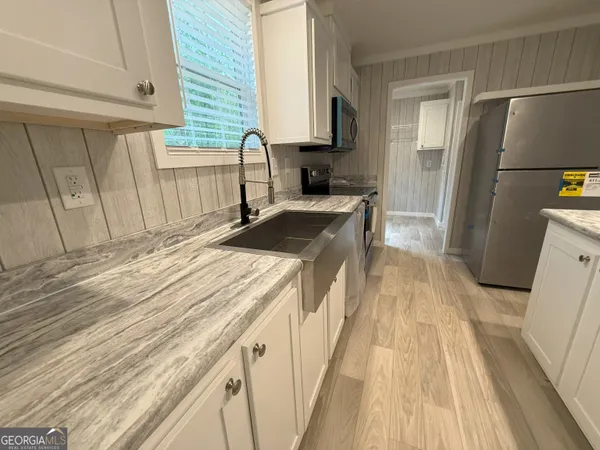 an empty room with windows and cabinet