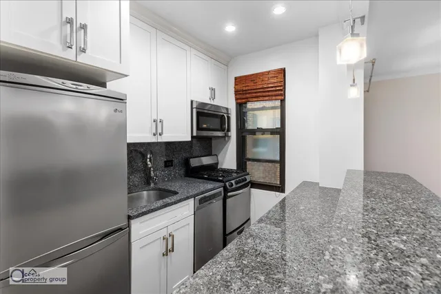 a kitchen with stainless steel appliances granite countertop a refrigerator and a stove top oven