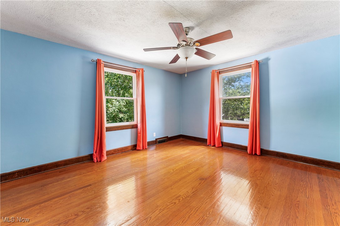 1623 Spangler Road Northeast Canton, OH 44714 - Photo 18 of 28 Unfurnished room with light wood finished floors, plenty of natural light, a textured ceiling, and a ceiling fan