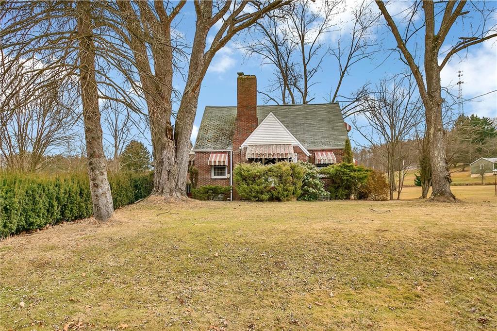 a front view of house with yard and trees around