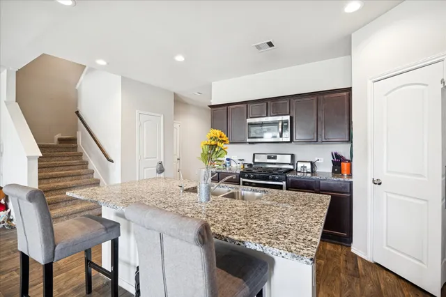 a kitchen with sink refrigerator and microwave