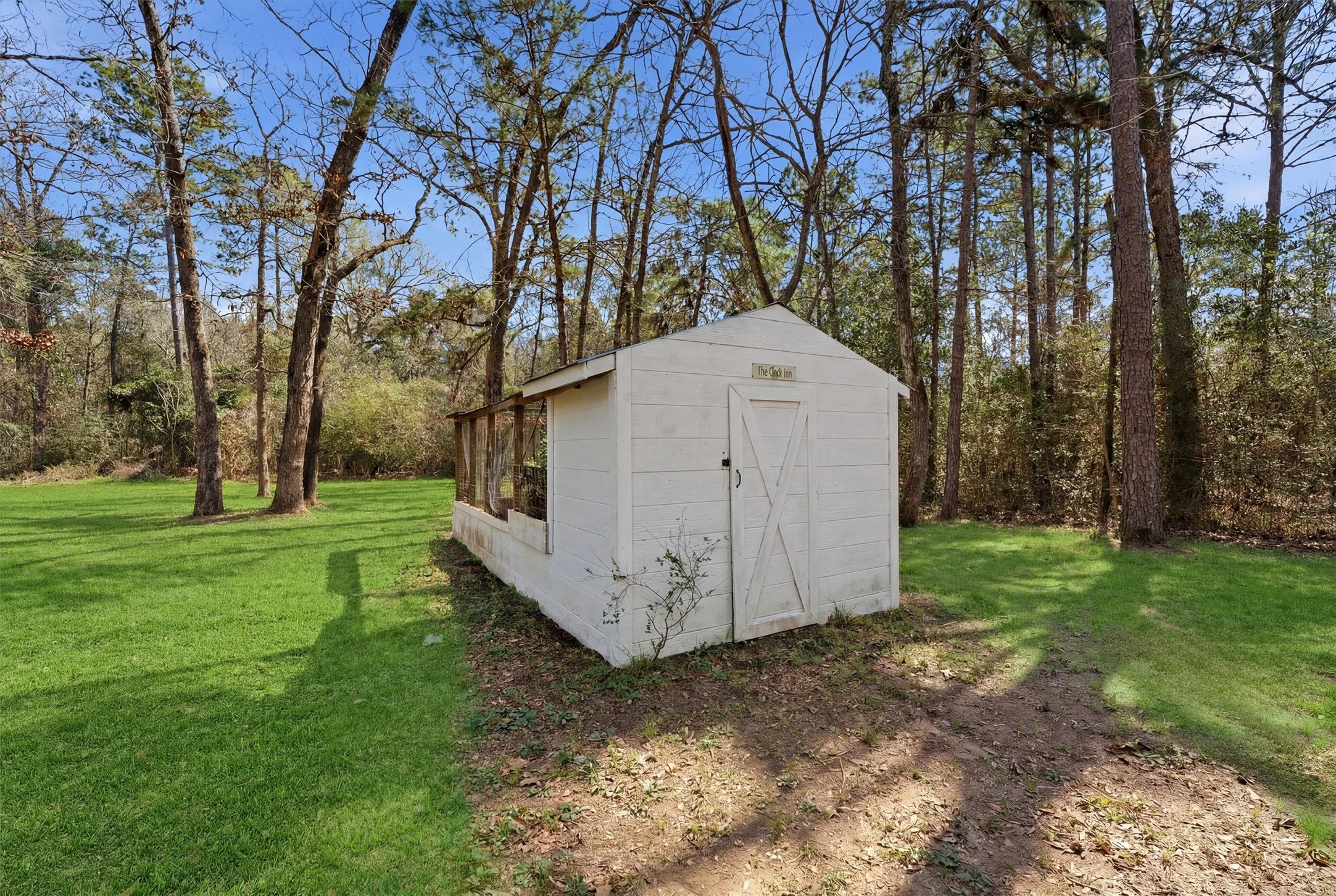 2920 Superior Road Magnolia, TX 77354 - Photo 41 of 46 a view of a small white house with a large tree and a yard