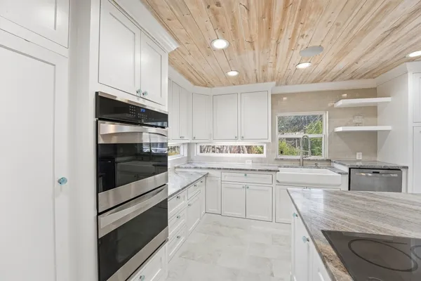 a kitchen with stainless steel appliances granite countertop a stove a sink and a refrigerator