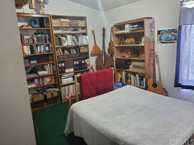 12285 Golden View Road Pinon Hills, CA 92372 - Photo 26 of 33 a living room with furniture and a book shelf