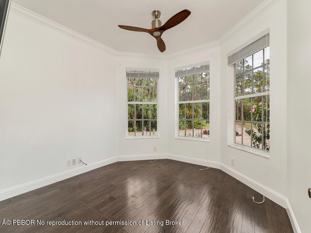 1001 Southeast Ranch Road Northeast Jupiter, FL 33478 - Photo 11 of 32 an empty room with wooden floor and windows