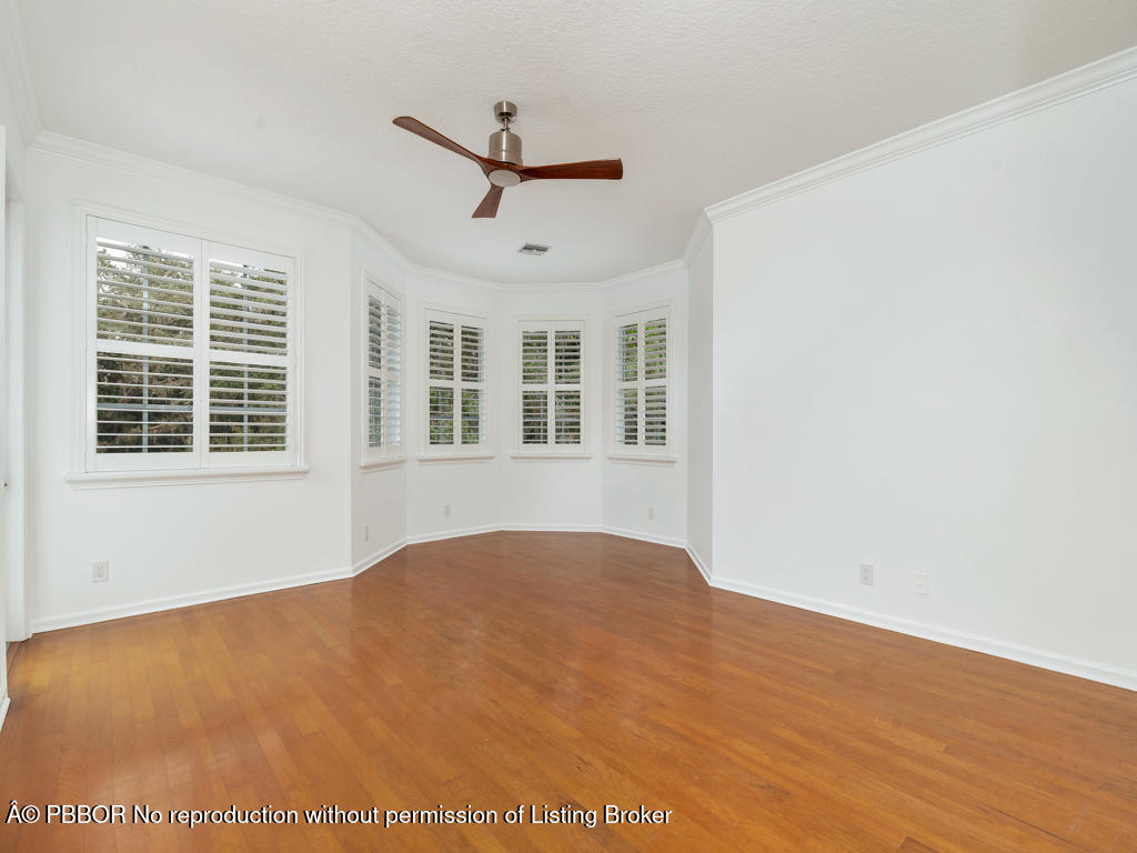 1001 Southeast Ranch Road Northeast Jupiter, FL 33478 - Photo 13 of 32 a view of an empty room with a window and wooden floor