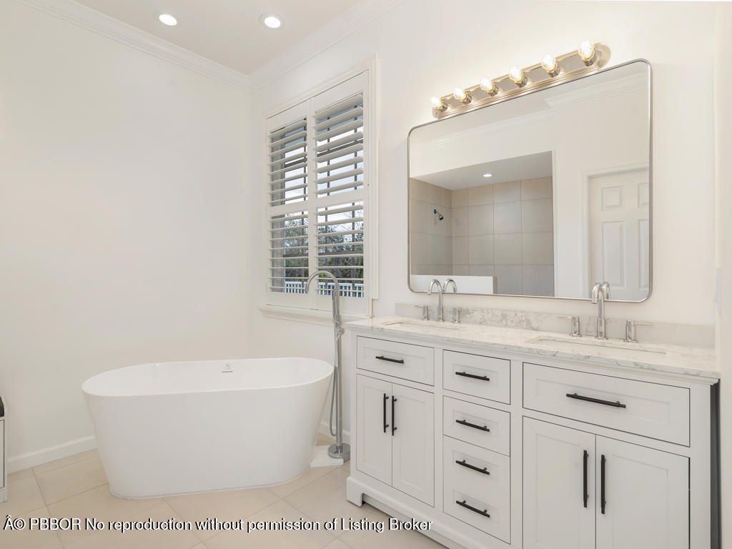 1001 Southeast Ranch Road Northeast Jupiter, FL 33478 - Photo 15 of 32 a bathroom with a granite countertop sink and a bathtub
