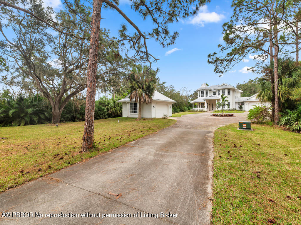 1001 Southeast Ranch Road Northeast Jupiter, FL 33478 - Photo 4 of 32 a view of road with large trees