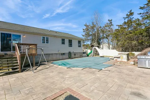 a view of a patio with a table and chairs under an umbrella