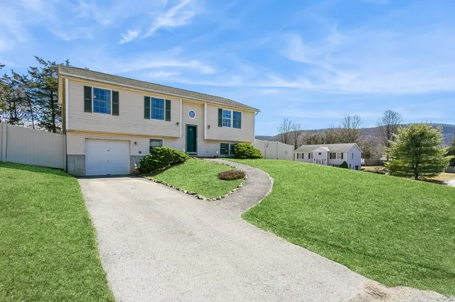 a front view of a house with a yard and garage