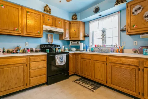 a kitchen with stainless steel appliances granite countertop a sink stove and cabinets