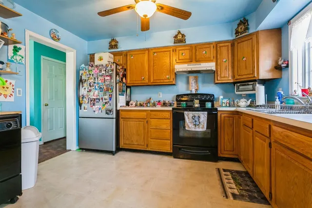 a kitchen with stainless steel appliances granite countertop a stove a sink and a refrigerator