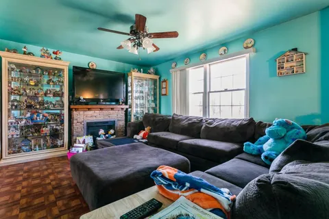a living room with furniture a flat screen tv and a fireplace