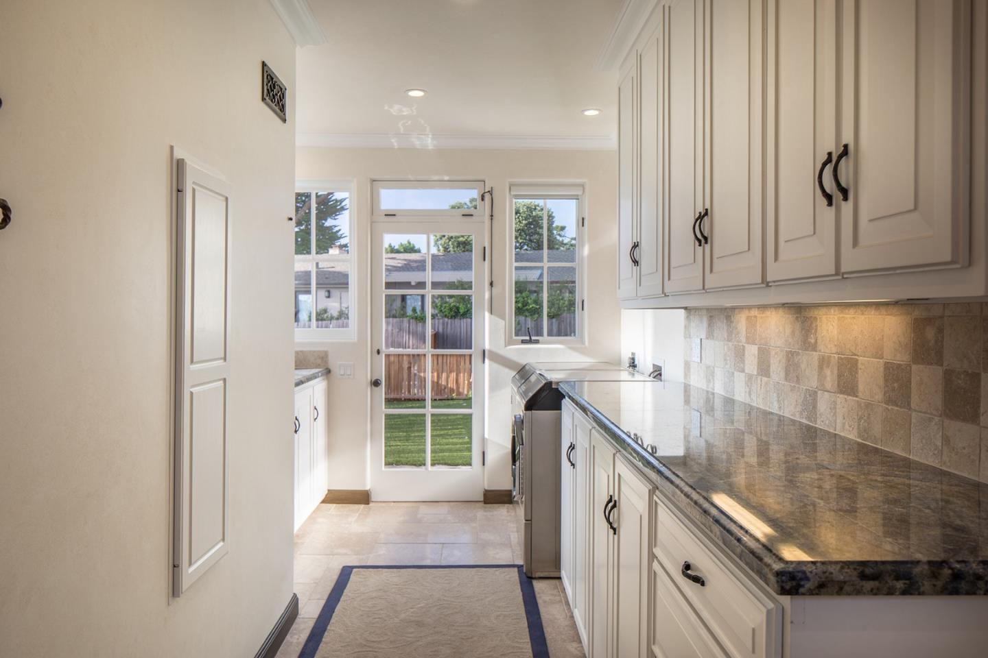 1011 Rodeo Road Pebble Beach, CA 93953 - Photo 14 of 41 a kitchen with granite countertop a sink a stove and cabinets