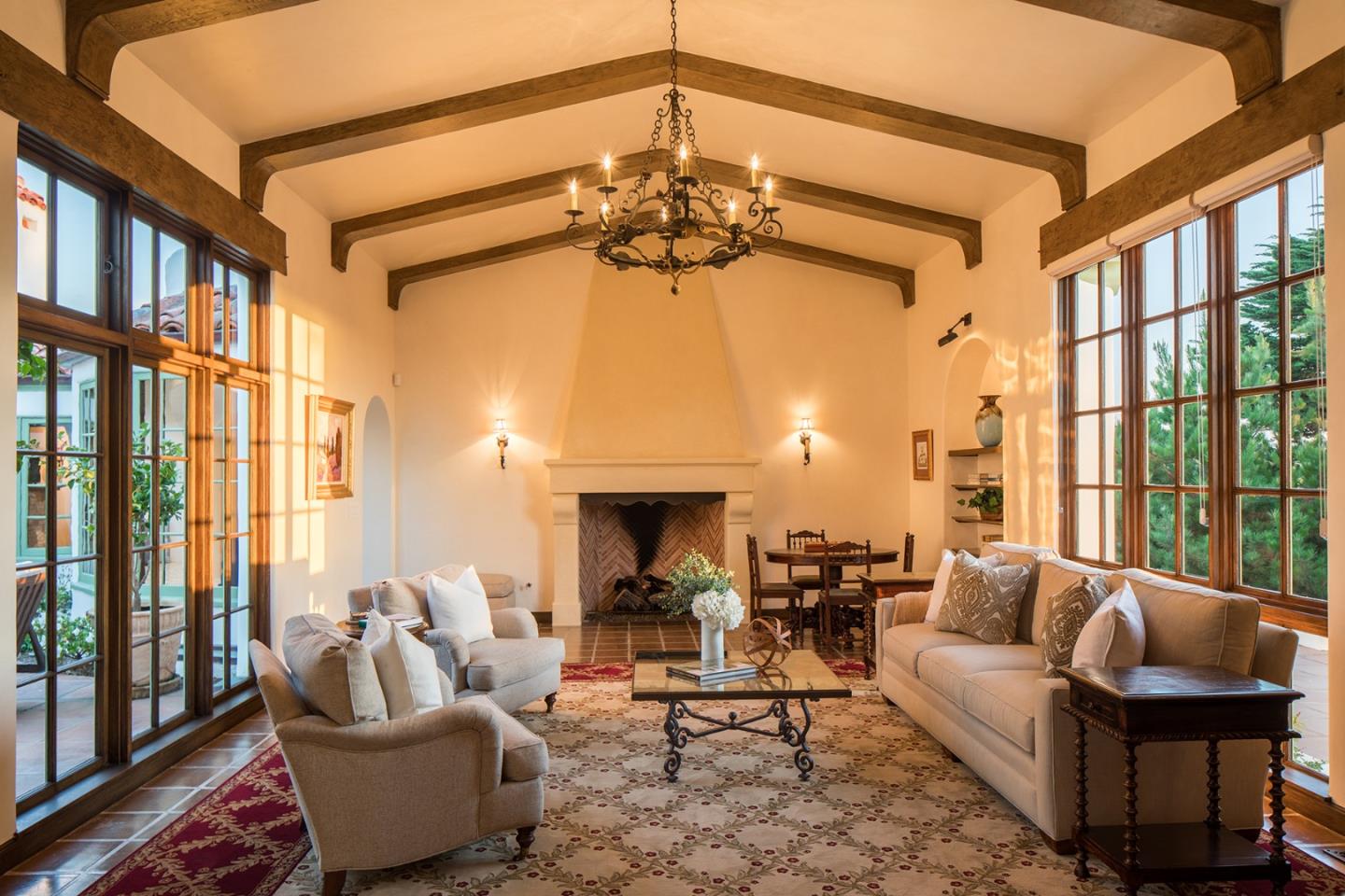 1011 Rodeo Road Pebble Beach, CA 93953 - Photo 17 of 41 a living room with furniture a fireplace and a chandelier