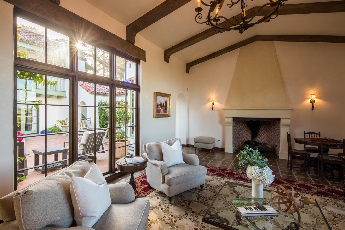 1011 Rodeo Road Pebble Beach, CA 93953 - Photo 18 of 41 a living room with furniture a fireplace and windows