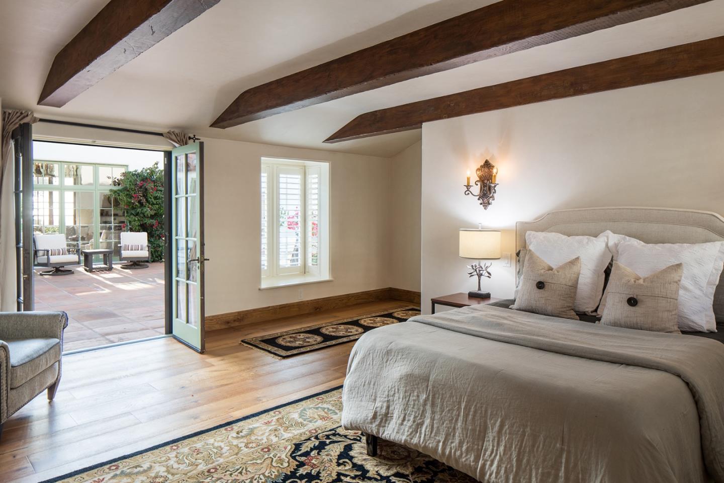 1011 Rodeo Road Pebble Beach, CA 93953 - Photo 30 of 41 a bedroom with a balcony a bed and a painting on the wall