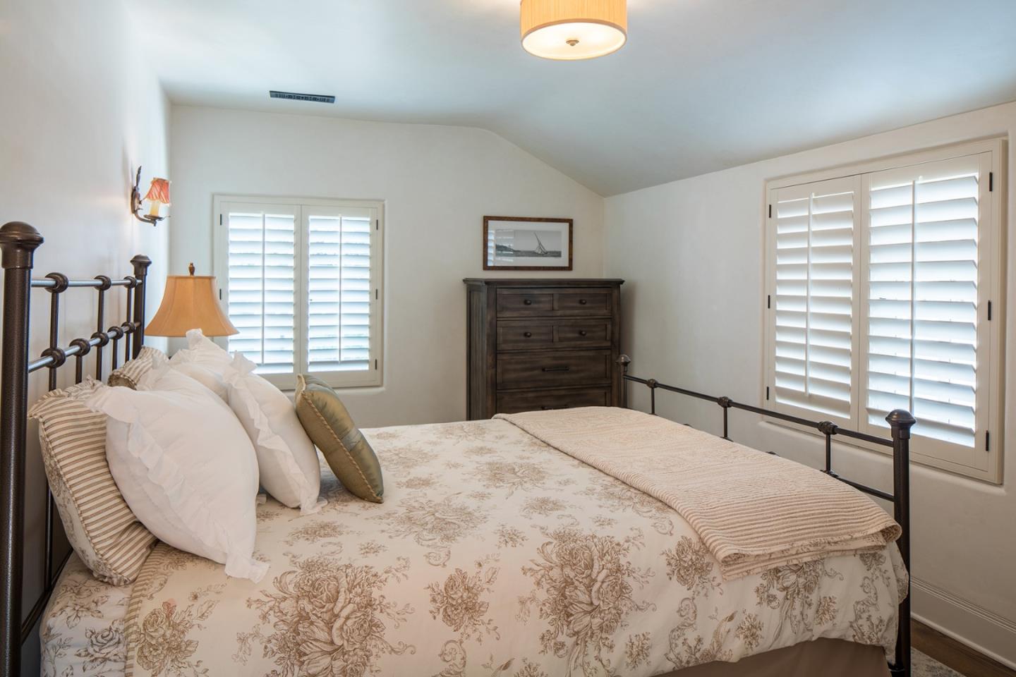 1011 Rodeo Road Pebble Beach, CA 93953 - Photo 34 of 41 a bedroom with a bed and dresser with windows