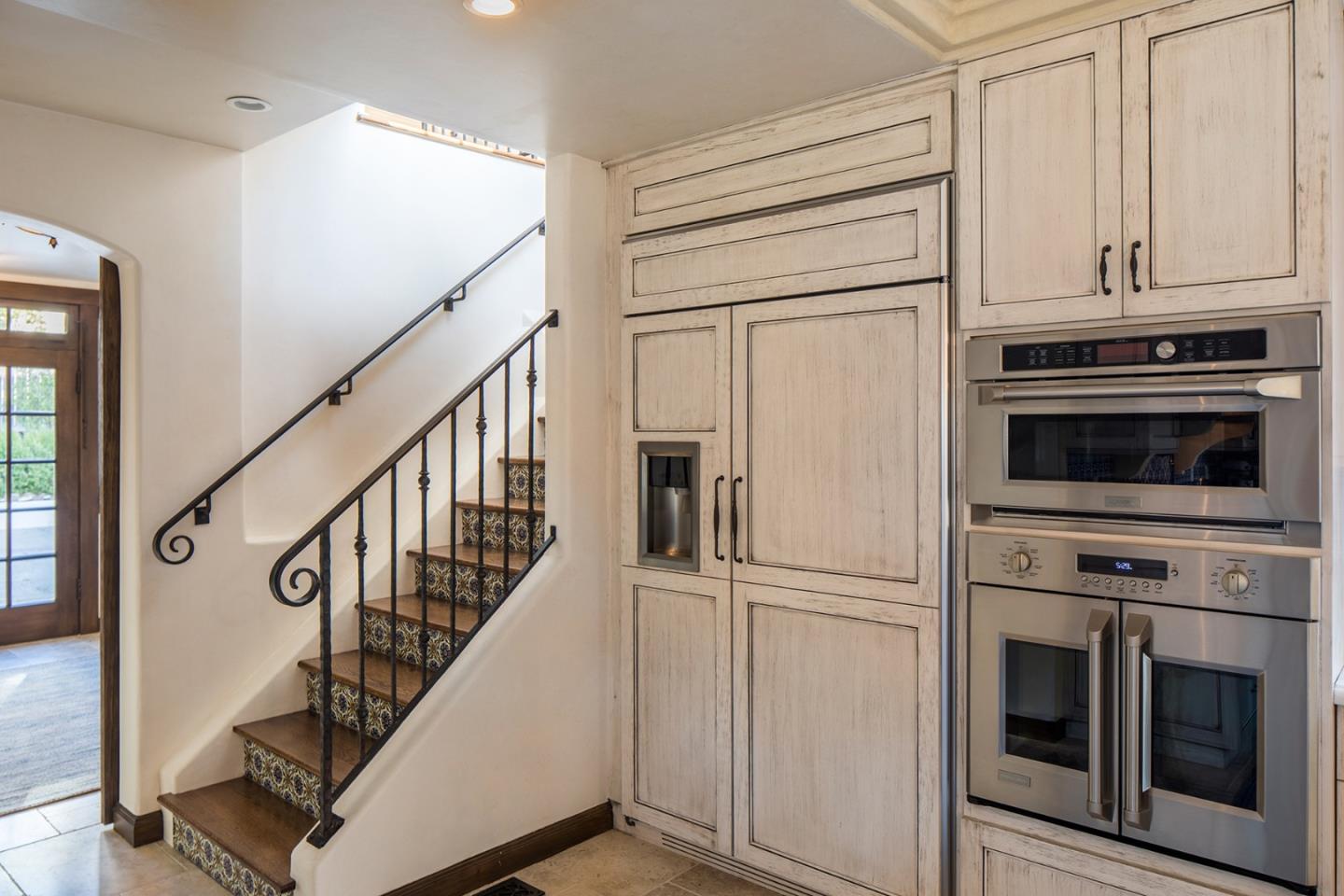 1011 Rodeo Road Pebble Beach, CA 93953 - Photo 9 of 41 a kitchen with white cabinets and stainless steel appliances