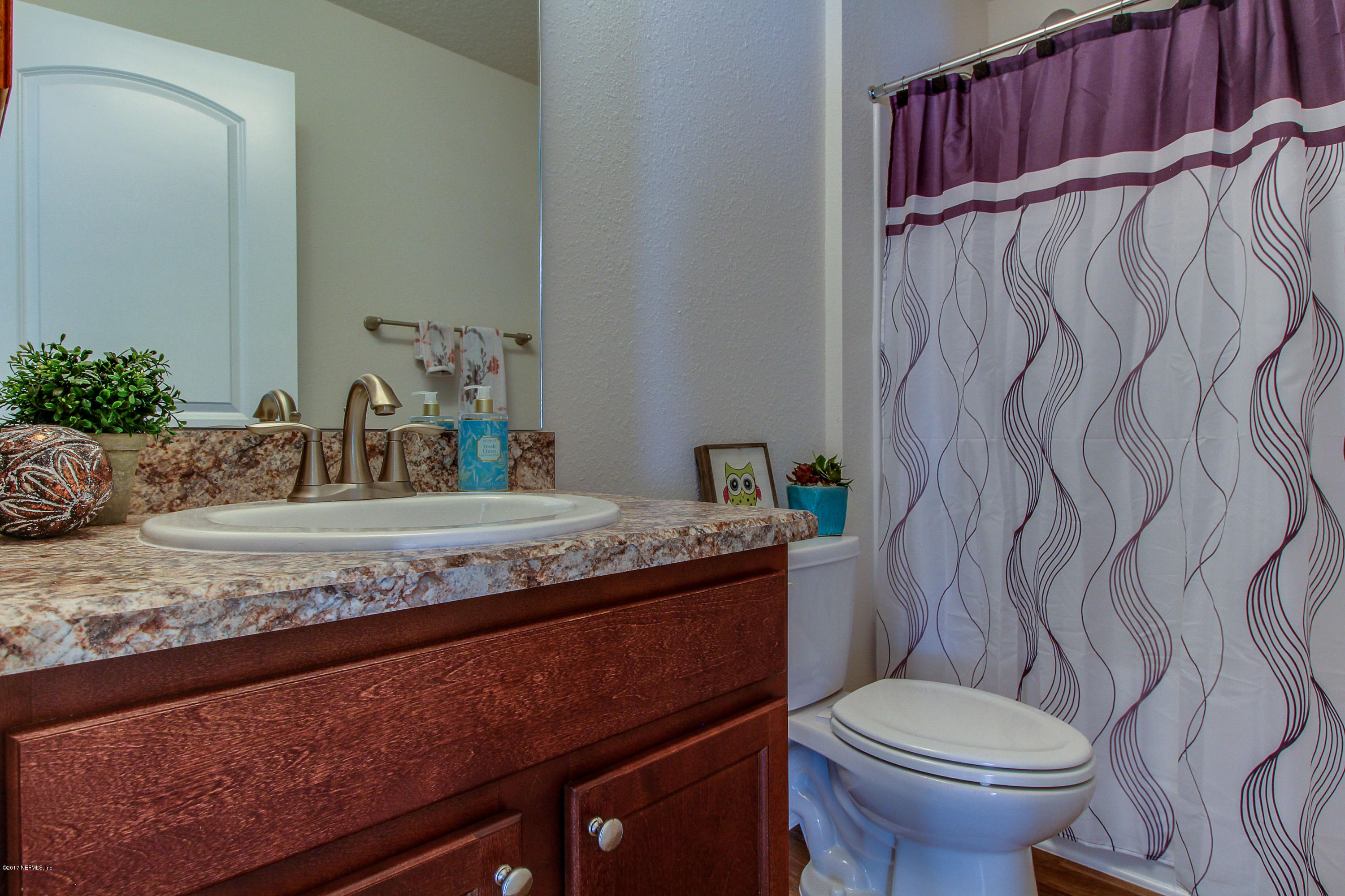 88442 Maybourne Road Yulee, FL 32097 - Photo 13 of 29 a bathroom with a granite countertop sink and a toilet
