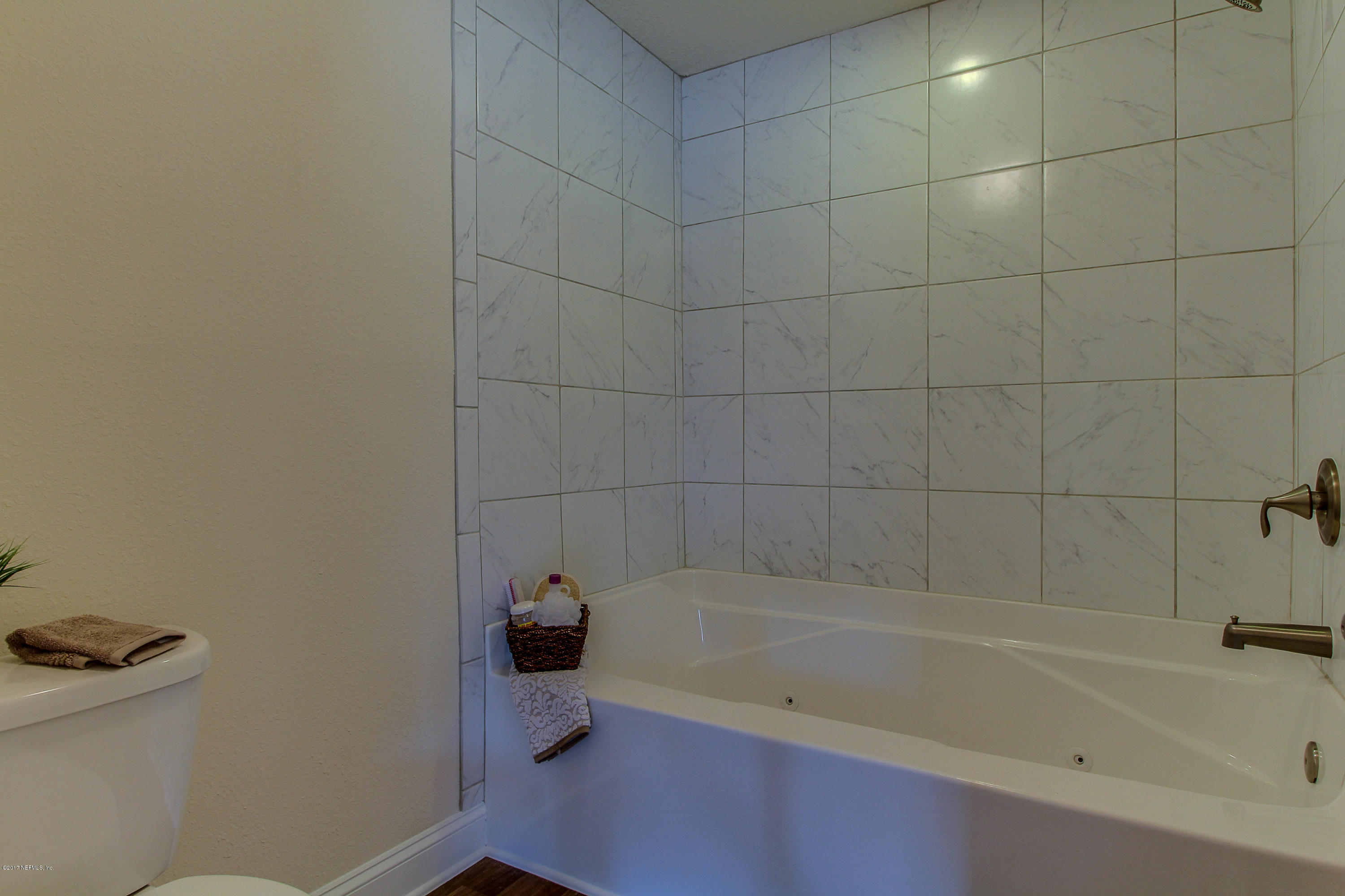88442 Maybourne Road Yulee, FL 32097 - Photo 20 of 29 a bath tub sitting next to a white toilet and a sink