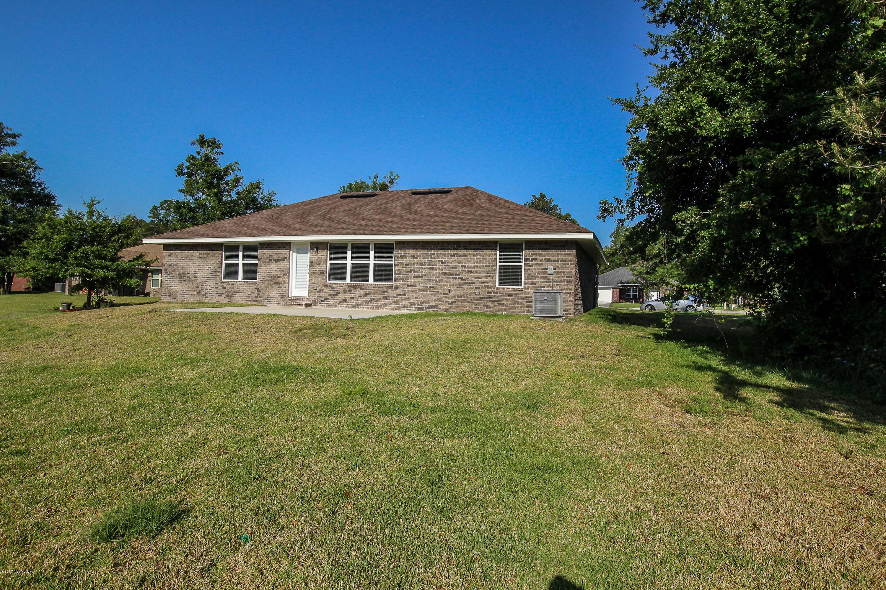 88442 Maybourne Road Yulee, FL 32097 - Photo 25 of 29 a front view of a house with a garden