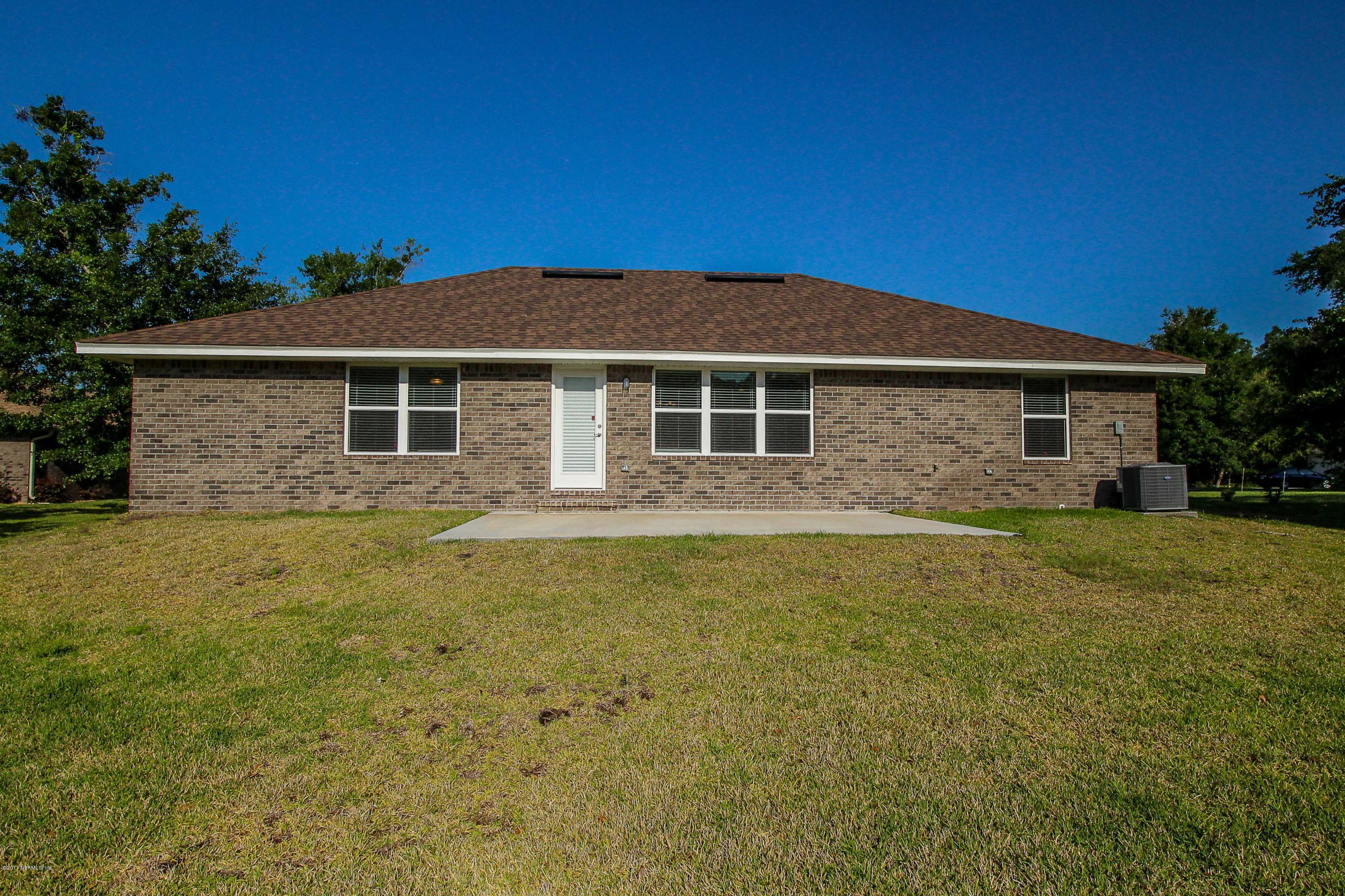 88442 Maybourne Road Yulee, FL 32097 - Photo 26 of 29 a front view of a house with a garden