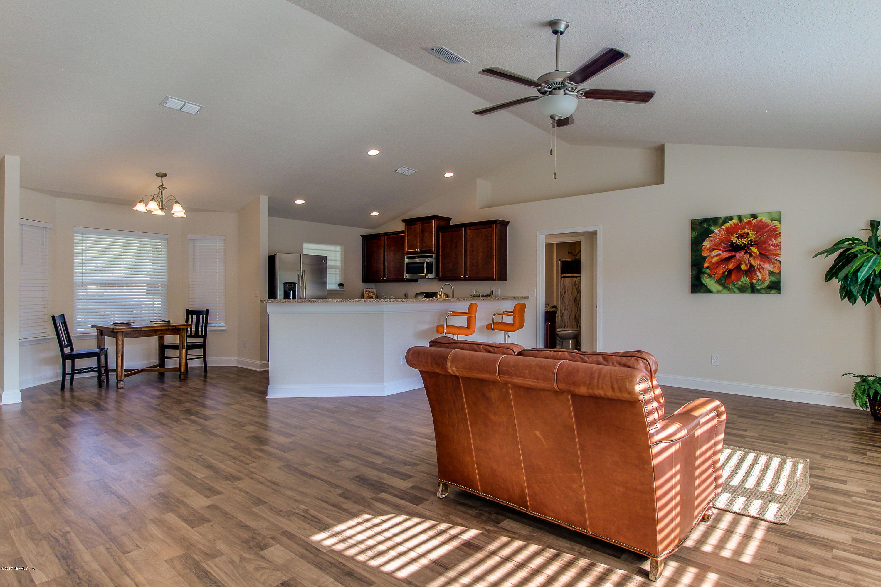 88442 Maybourne Road Yulee, FL 32097 - Photo 5 of 29 a living room with furniture kitchen view and a wooden floor