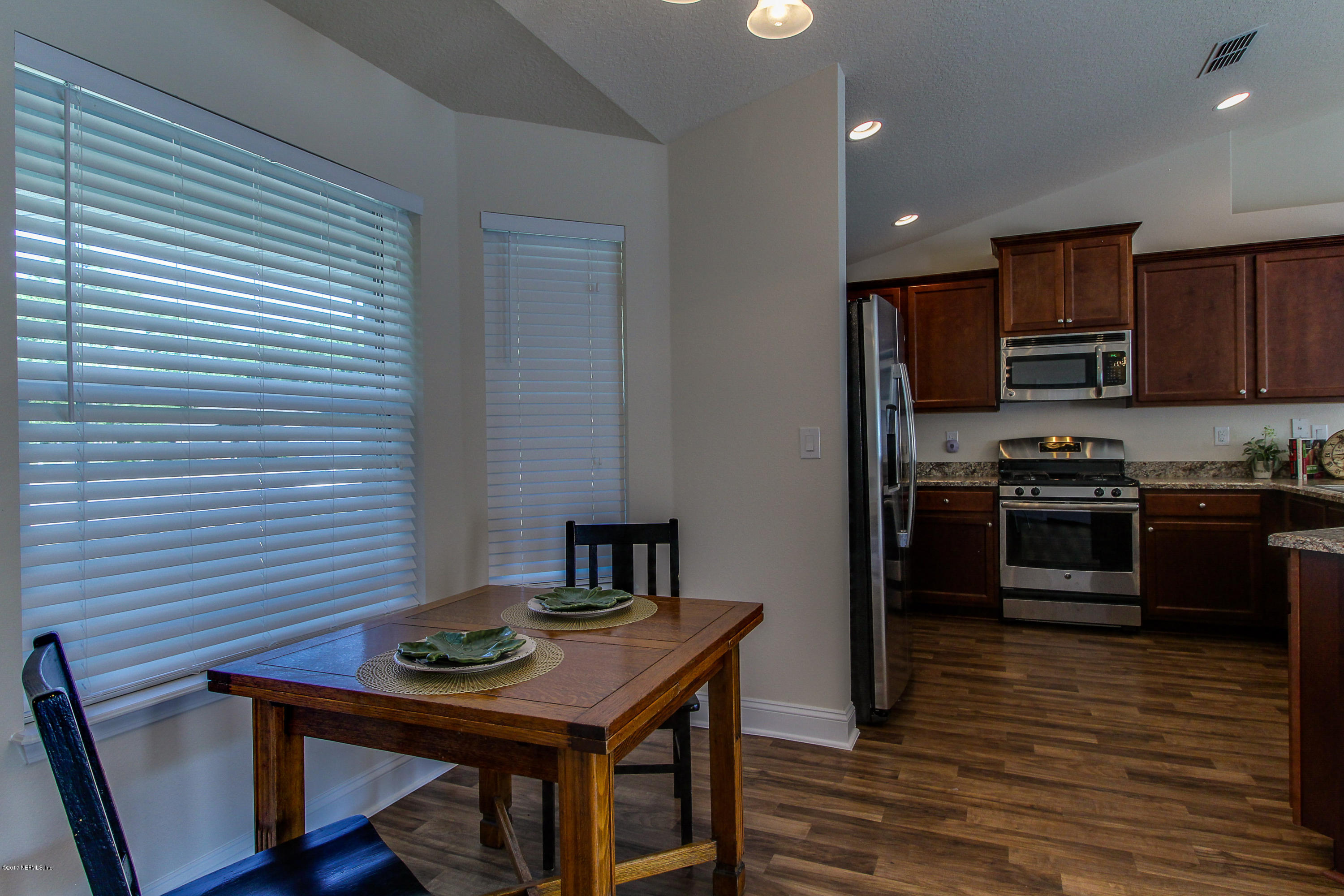 88442 Maybourne Road Yulee, FL 32097 - Photo 7 of 29 a kitchen with stainless steel appliances a refrigerator and a stove top oven