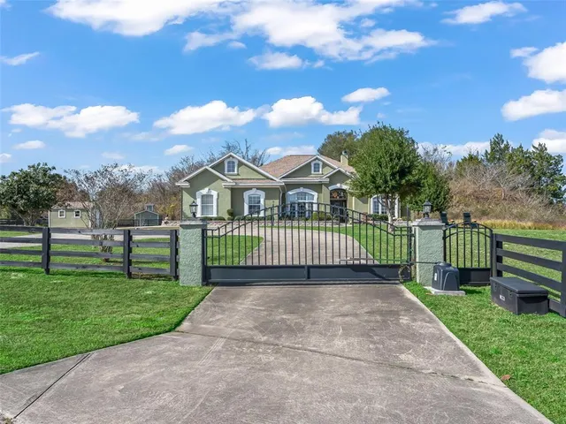 a view of a house with a yard and fence