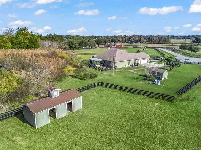 an aerial view of a residential houses with outdoor space and a lake view