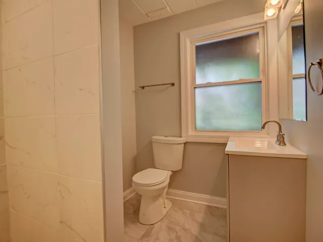 a bathroom with a toilet sink and mirror