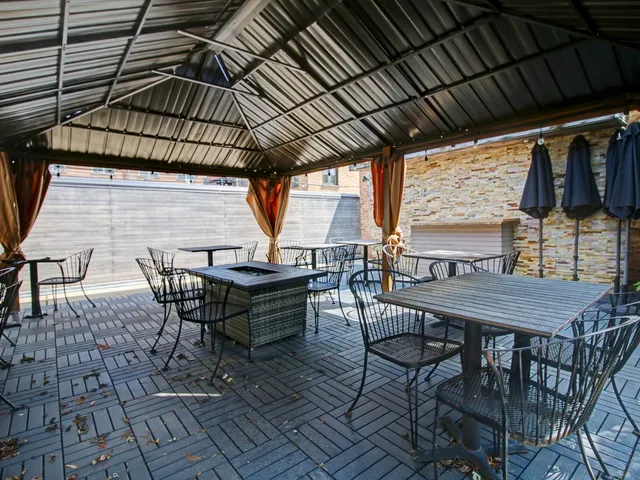 a view of a backyard with table and chairs with wooden floor and fence