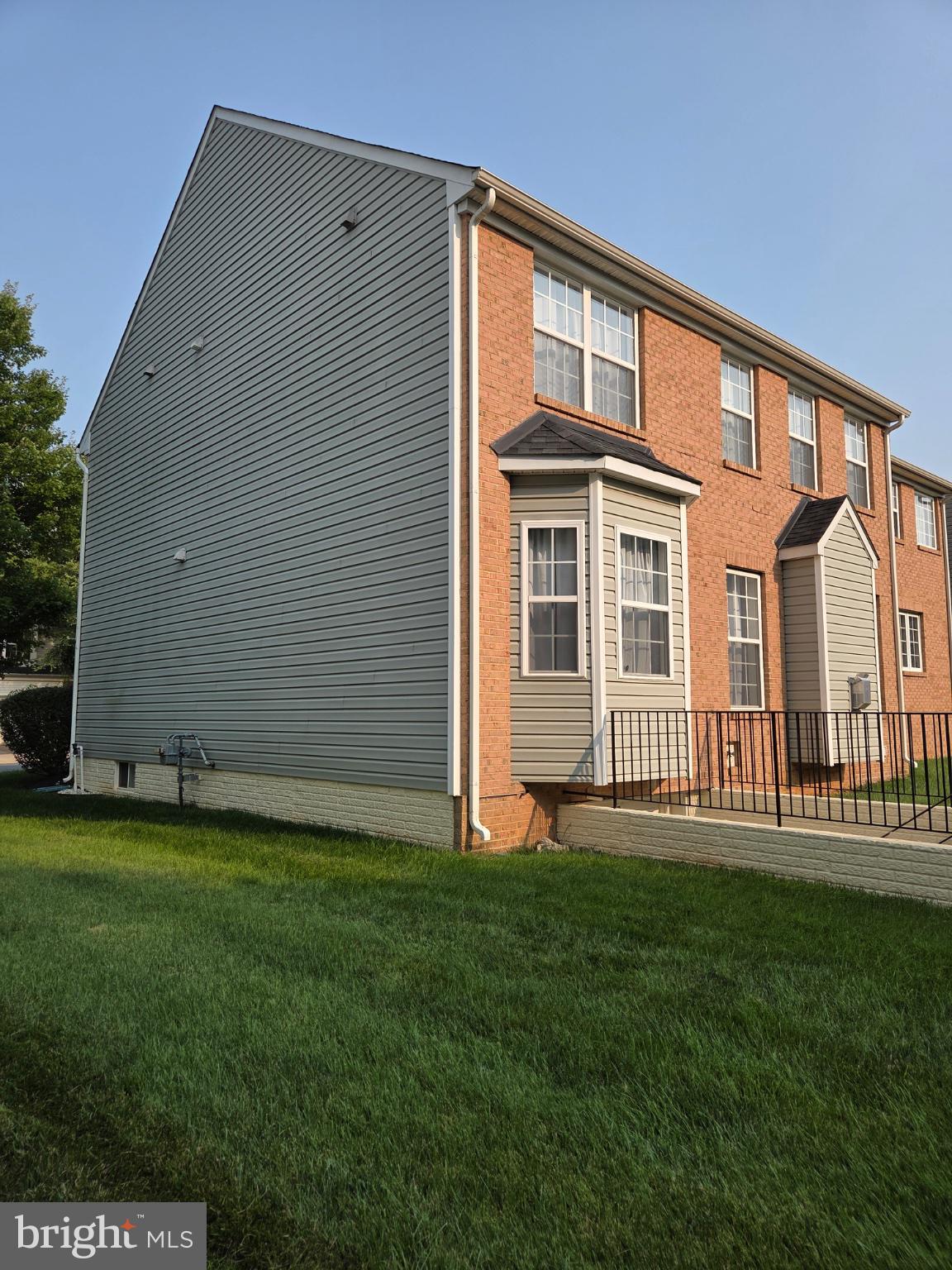 Charming brick home with lush lawn.