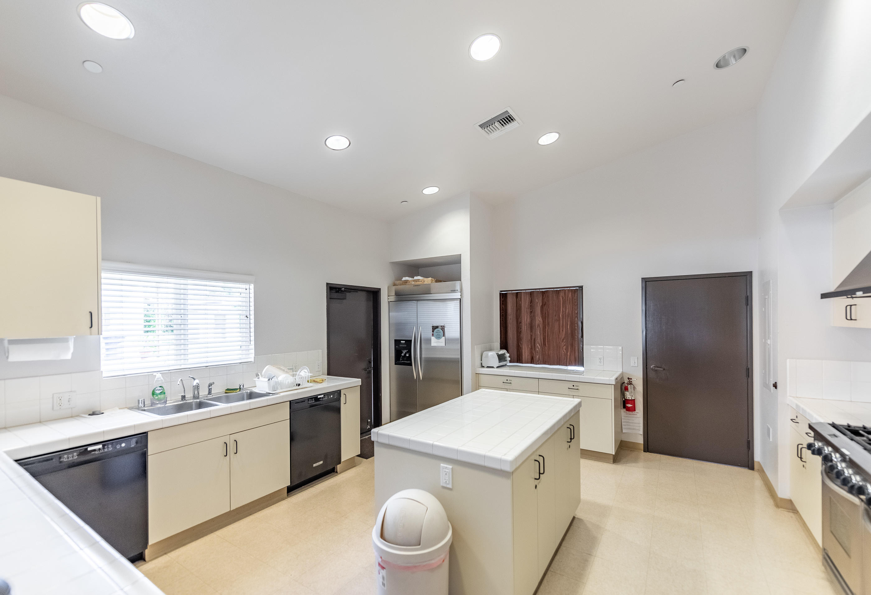 3950 Via Real, Unit 129 Carpinteria, CA 93013 - Photo 33 of 35 a kitchen with a refrigerator a sink dishwasher with a dining table and chairs