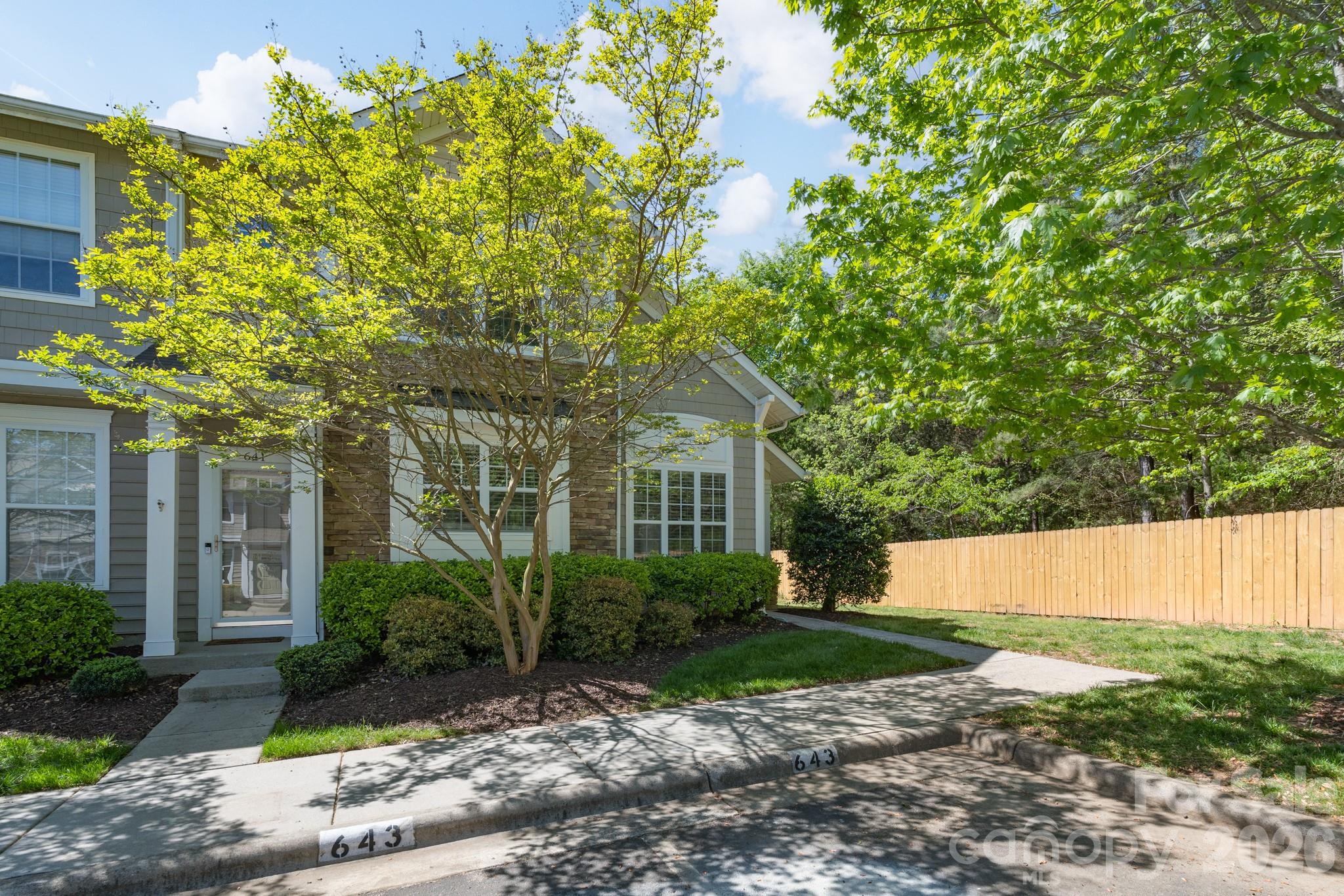 a front view of a house with a yard and a garden