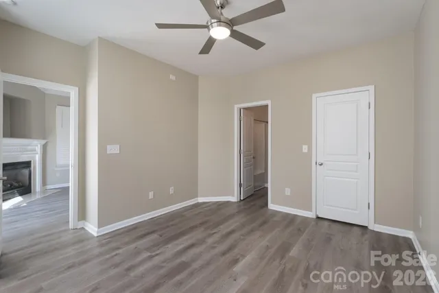 an empty room with wooden floor a ceiling fan and closet