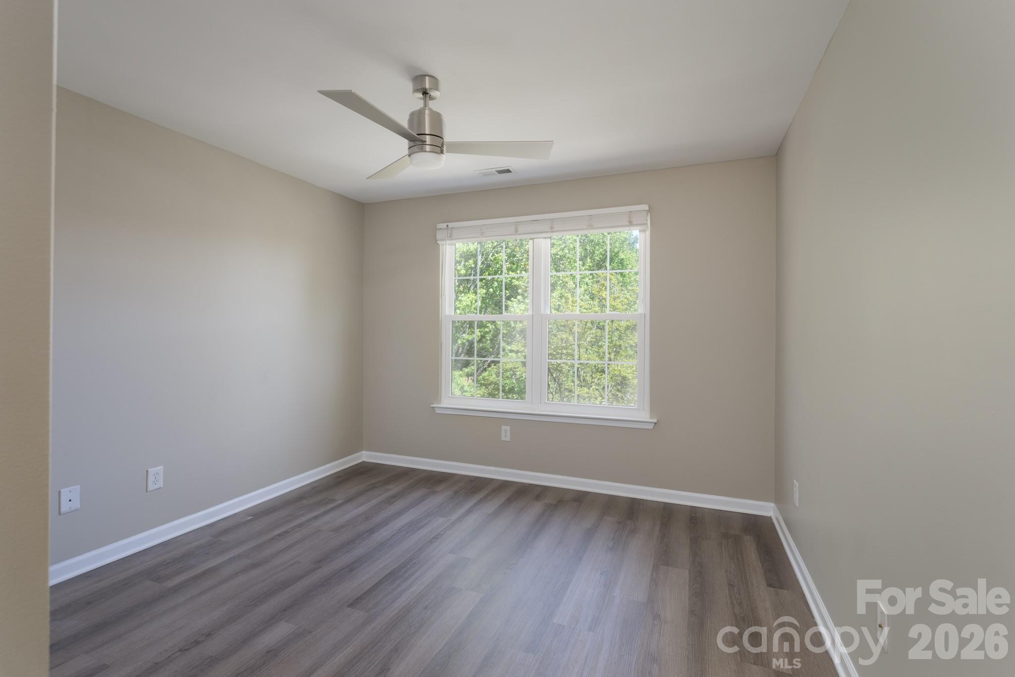 643 Brickdust Court Fort Mill, SC 29708 - Photo 18 of 28 an empty room with wooden floor chandelier fan and windows