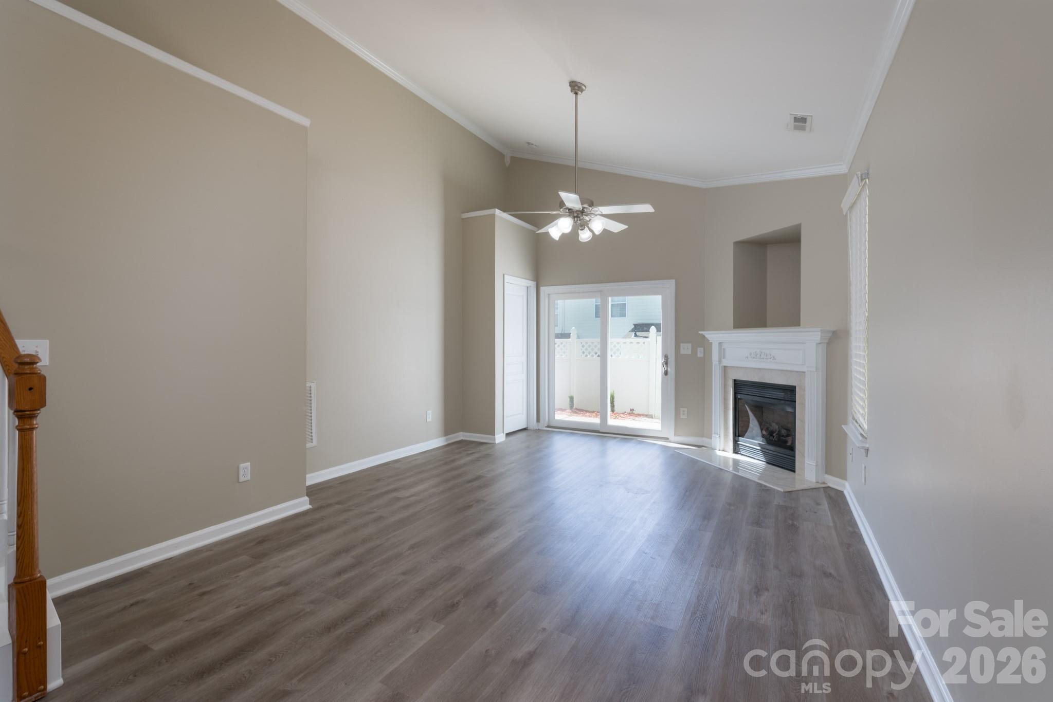 643 Brickdust Court Fort Mill, SC 29708 - Photo 4 of 28 an empty room with wooden floor fireplace and chandelier