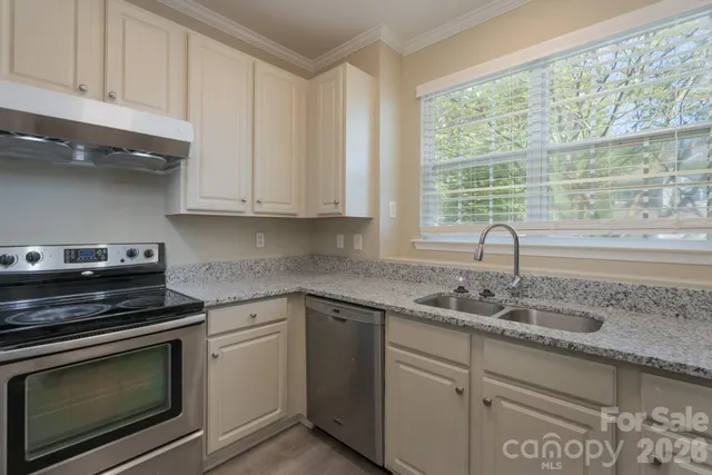 a kitchen with granite countertop white cabinets and appliances