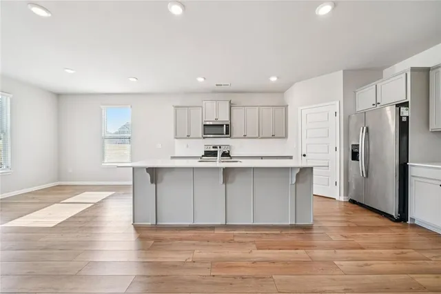 a kitchen with granite countertop a refrigerator and a stove top oven