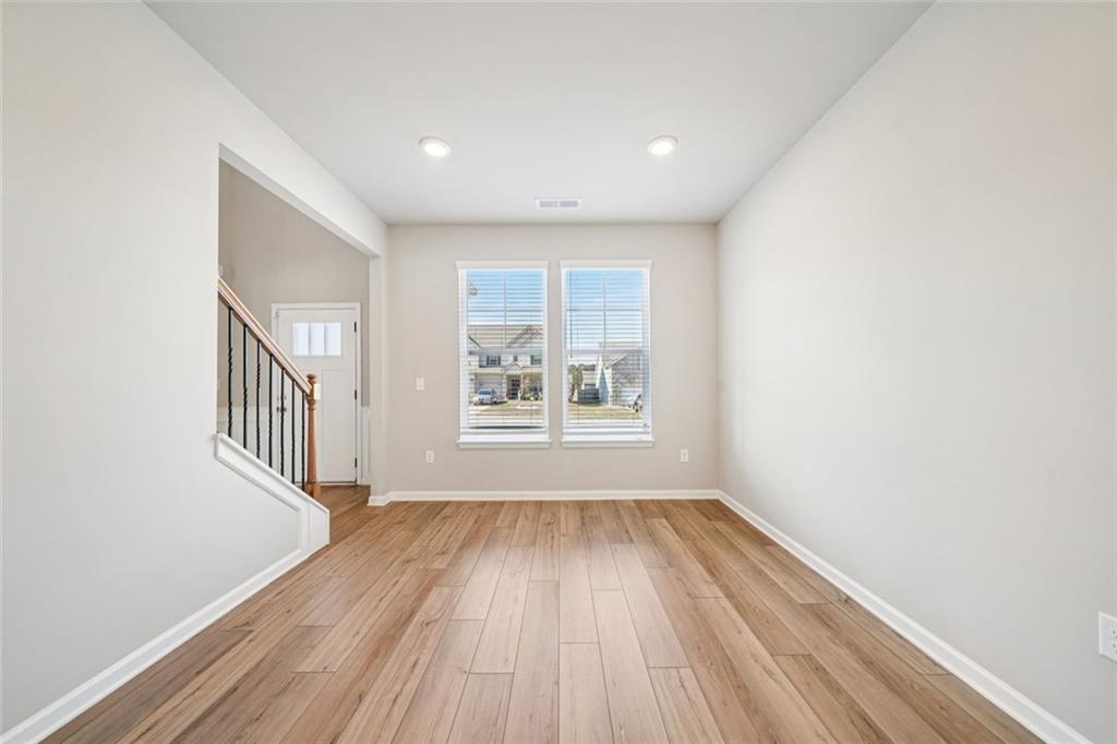 1547 Stinson Lane Locust Grove, GA 30248 - Photo 15 of 43 a view of an empty room with wooden floor and a window