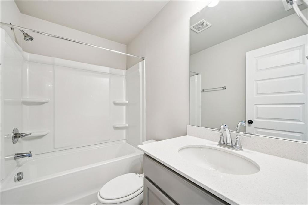 1547 Stinson Lane Locust Grove, GA 30248 - Photo 22 of 43 a bathroom with a granite countertop sink toilet and shower