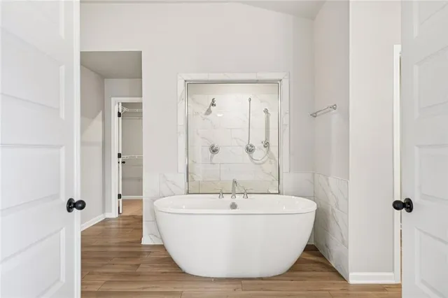 a white bath tub sitting in a bathroom and mirror