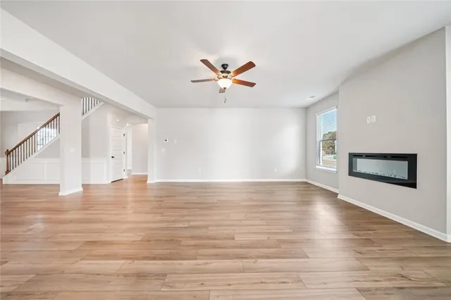 a view of an empty room with window and wooden floor