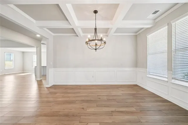 a view of empty room with wooden floor and window